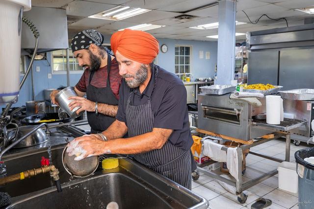 Two sevadars washing up in the langar kitchen