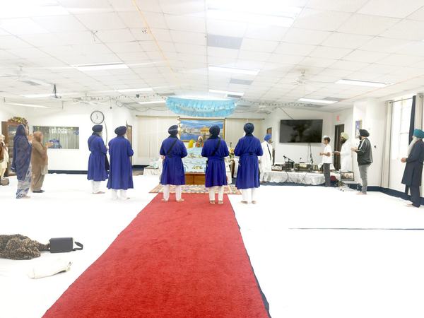 Sevadars preparing the new Nishan Sahib pole during Nishan Sahib Sewa at Gurdwara Akaljot, Garland TX