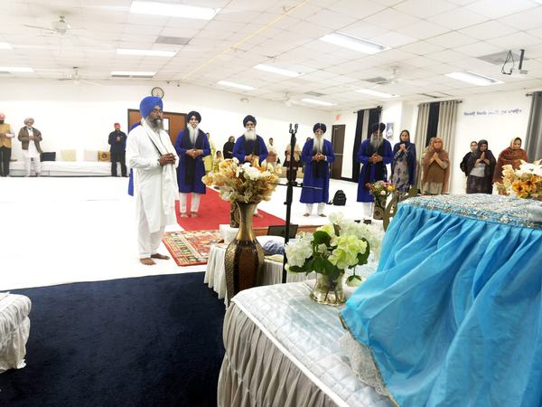 Sevadars wrapping the Nishan Sahib in fresh chola cloth, Gurdwara Akaljot