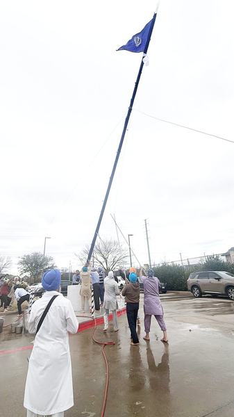 The Nishan Sahib raised again in its new saffron chola at Gurdwara Akaljot