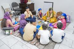 Children and teachers sitting in a circle during a Punjabi class
